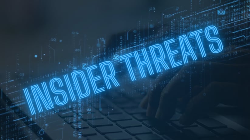 Neon blue text reading “Insider Threats” over a dim laptop keyboard with faint digital code lines.